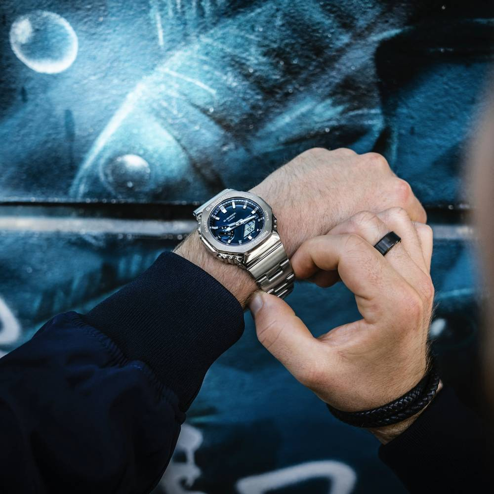 Casio GM-2110D-2BER G-Shock - Унисекс ръчен часовник с кварцов механизъм - корпус от Стомана - Стоманена верижка - цвят Сребрист